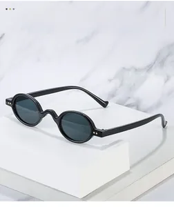 Detail of vintage round black sunglasses featuring a wavy bridge and thin metal temples