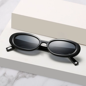 Lunettes de soleil ovales noires rétro avec monture épaisse sur socle en marbre