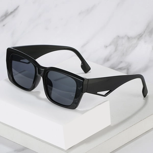 Oversized black square sunglasses with wide hollow triangle temples on marble background