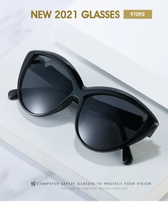 Macro detail of glossy black cat-eye sunglasses with gradient lenses on marble base