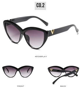 Detail view of black cat eye sunglasses featuring gold V logo and gradient purple lenses