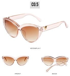 Detail view of pink cat eye sunglasses with V-shaped gold hinge and gradient lenses