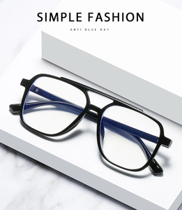 Top view of black aviator style TR90 glasses with anti-blue light lenses on a white stand