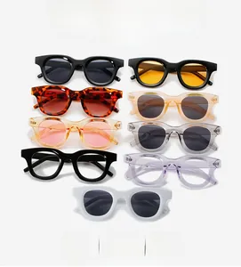 Flat lay of retro oval sunglasses in diverse colors including tortoiseshell and ivory white