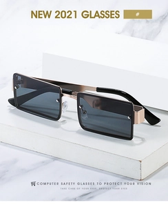 Detail of square computer safety glasses with wide gold metal legs on marble stone