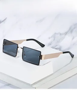 Detail of rimless square sunglasses with grey lenses and wide golden metal temples