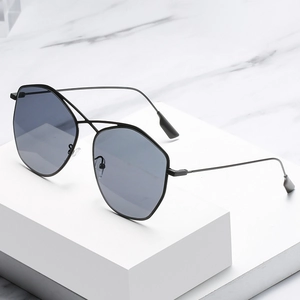 Occhiali da sole poligonali in metallo alla moda con lenti grigio scuro su base minimalista