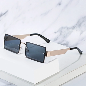 Square rimless sunglasses with gold metal temples and dark grey lenses on white stone