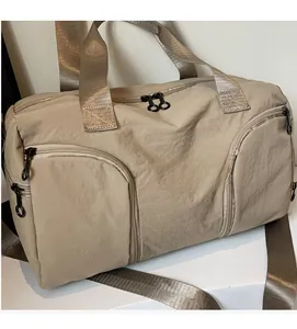 Detail of khaki travel bag with lightweight fabric, zipper pockets and wide shoulder strap