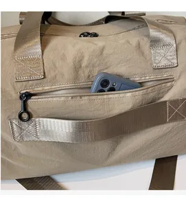 Close-up of khaki waterproof nylon travel bag showing functional side zipper pocket