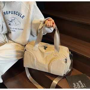 Detail of canvas travel bag featuring large front pockets and wide woven handles