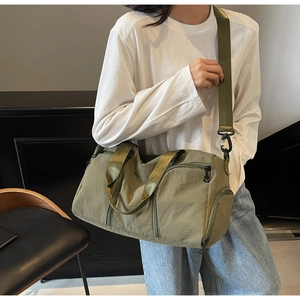 Detail shot of army green nylon travel bag with wide straps and functional pockets