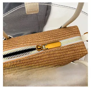 Detail of metal zipper closure on straw-woven inner bag with transparent PVC exterior