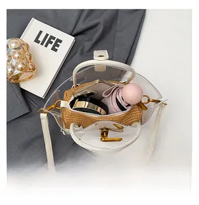 Detail view of transparent PVC basket bag with straw inner pouch showing daily storage capacity