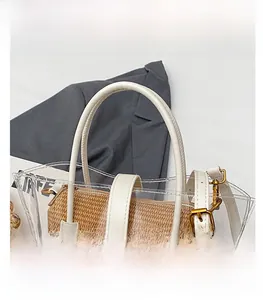Detail of transparent PVC tote bag with straw woven inner and white leather handles