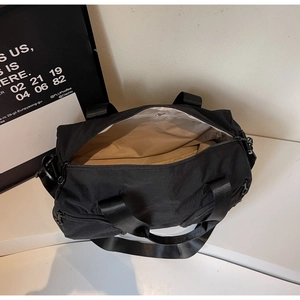 Top view of large black nylon travel bag showing interior lining and wide shoulder strap