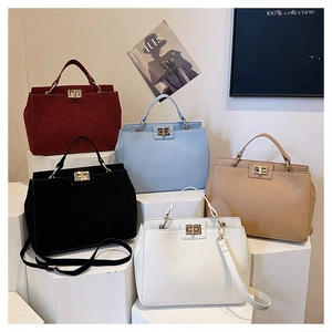 Detail showing five colors of textured leather tote bags with gold twist locks and suede panels