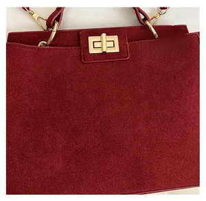 Detail of burgundy frosted tote bag featuring a golden rectangular twist-lock clasp