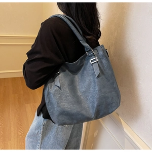 Gray-blue soft leather tote bag on shoulder, showing capacity and textured PU leather