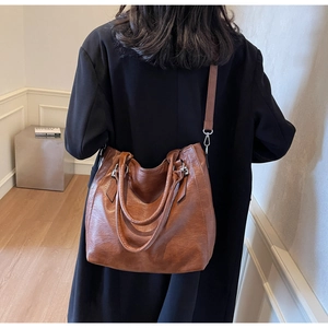 Detailed view of the brown leather tote bag texture and sleek silver hardware finish