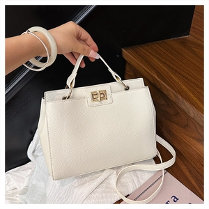 Detail of white lychee pattern leather handbag with gold turn-lock on a wooden step