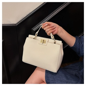 Detail of off-white lychee texture leather handbag with golden square twist lock