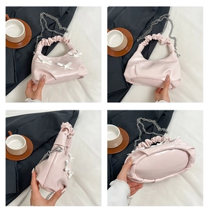 Detailed views of the light pink pleated crossbody bag with white bows and chain strap