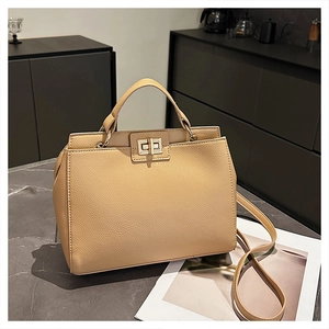 Close-up of beige litchi grain leather texture and elegant gold metallic rotating lock
