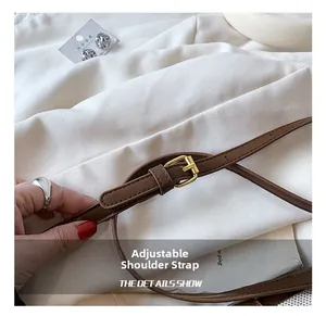 Detail of adjustable dark brown leather shoulder strap with golden buckle and fine stitching