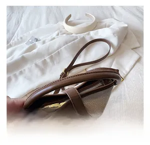 Close-up of dual-tone bucket bag featuring woven texture and brown leather handle