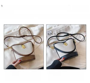 Detail view of canvas bucket bags in brown and black with leather trim and metal locks