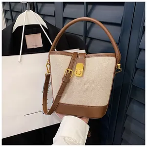 Detail of color-block bucket bag showing canvas texture, leather trim and metal lock