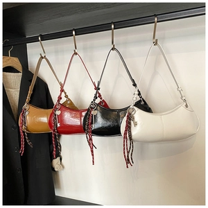 Row of colorful crescent hobo bags in oil wax leather with heart charms and woven ropes