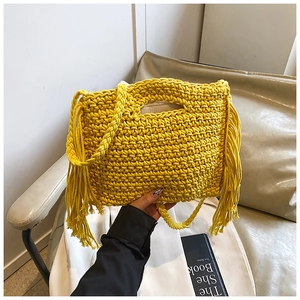 Detailaufnahme der gelben Häkeltasche mit langen Fransen und dekorativen Metallringen