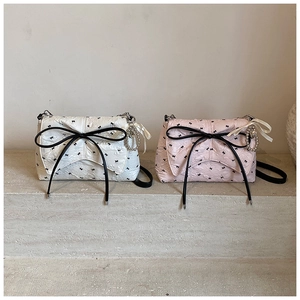 Detalle de bolsos bandolera con lazos en blanco y rosa con tela plisada y cintas