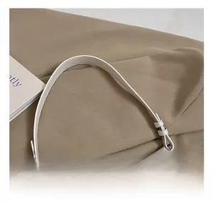 Close-up detail of the comfortable white leather handle with high-quality stitching on handbag