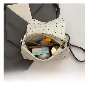 Interior del bolso bandolera blanco que muestra compartimentos amplios y capacidad