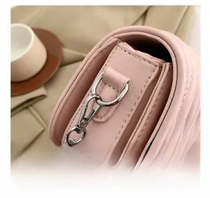 Detail of pink quilted leather bag featuring silver hardware and rhinestone logo