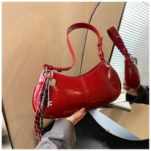 Macro shot of red patent leather moon bag with glossy finish and silver key charm