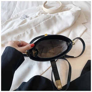 Detail view of the black bucket bag interior showing striped lining and gold hardware