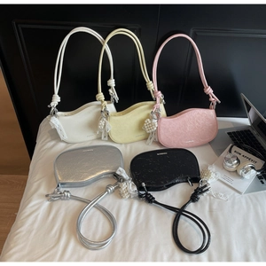 Detail showing various colors of crescent shoulder bags with lace bow and pearl charms