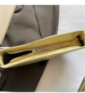 Detail showing smooth silver metal zipper closure on yellow leather shoulder bag