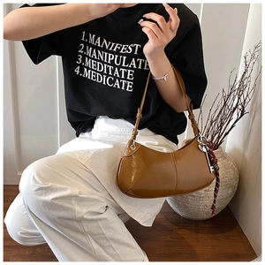 Close-up of brown crescent underarm bag with glossy leather and silk scarf detail