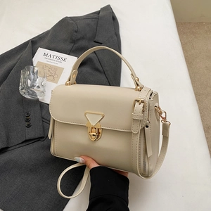 Chic beige crossbody bag with gold triangle lock and handle for minimalist office wear