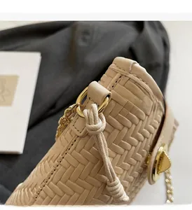Detailed close-up of beige woven texture bag with premium gold metal hardware and chain