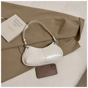 Detailed close-up of white crescent moon bag on khaki blazer showing smooth leather texture