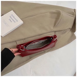 Inside view of red patent leather crescent bag with silver hardware and fabric lining