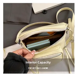 Vue détaillée de l'intérieur du sac à bandoulière crème montrant sa grande capacité