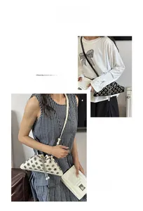 Detail view of rivet studded triangular bucket bag with pearl chain and eyelets