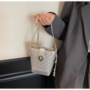 Detail of silver woven bucket bag with gold chain strap and metal swivel lock